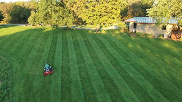 Overhead view of Landscape Plus maintenance team cutting a large lawn using professional lawn care equipment.